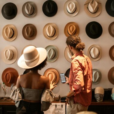A stylish couple exploring a hat boutique, showcasing diverse headwear.
