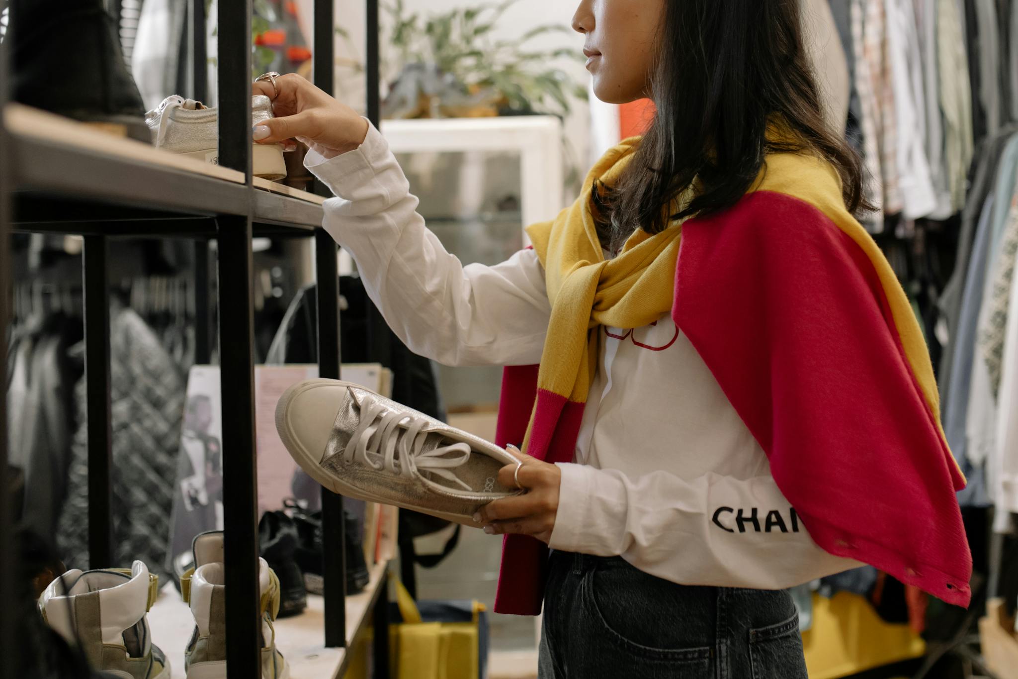 A woman browsing sneakers in a thrift store, showcasing the retail shopping experience.